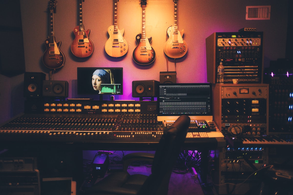 Professional audio mixing console with illuminated VU meters and analog channel strips in a recording studio